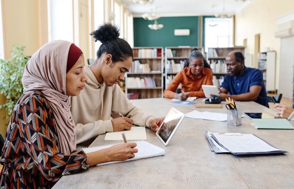 Gruppe junger Menschen lernt zusammen für Deutschkurs